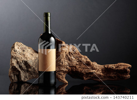 Bottle of red wine with old driftwood and a piece of granite rock. Bottle of red wine with old driftwood and a piece of granite rock. 143740211