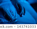 Intimate medication moment. Soft focus captures delicate pill administration scene. Serene image showcasing person handling medication with gentle care in ambient lighting 143741033