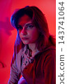 Creative night scene. Musician in evening atmosphere. Portrait of artist with soft hoodie glow. Nighttime artistic depiction featuring musician in ambient lighting 143741064