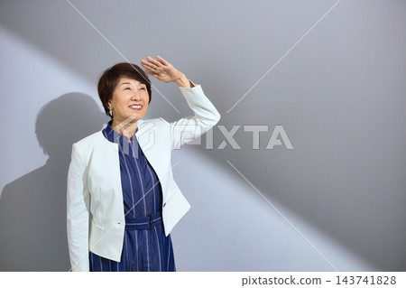 一位六十多歲、穿著外套、笑容燦爛的可愛女士。 143741828