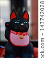 Black Maneki-neko (beckoning cat): A black Maneki-neko is a popular lucky charm believed to ward off evil and misfortune. 143742028