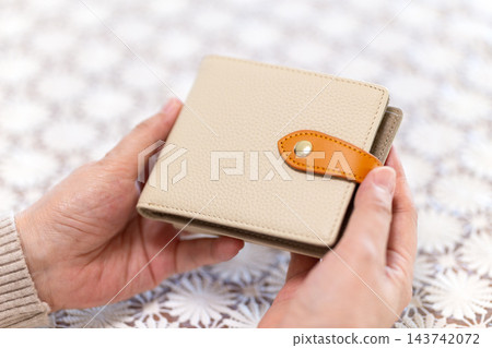 中老年婦女拿著錢包的手 中老年婦女拿著錢包的手 143742072