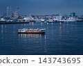 A lit-up sightseeing boat and a Japan Coast Guard patrol vessel sailing through Yokohama Port at dusk. A lit-up sightseeing boat and a Japan Coast Guard patrol vessel sailing through Yokohama Port at dusk. 143743695