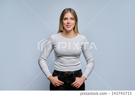 Smiling young female student in casual white sweater on grey background Smiling young female student in casual white sweater on grey background 143743715