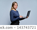 Young female student blonde woman holding laptop looking at camera studio portrait 143743721
