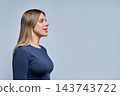 Profile view of smiling young woman looking ahead on studio background 143743722