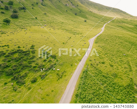 Aerial view of a scenic mountain valley with a winding road through the rugged landscape of Brecon Beacons National Park in Wales, United Kingdom Powys, Wales - 28 August 2026. 143743880