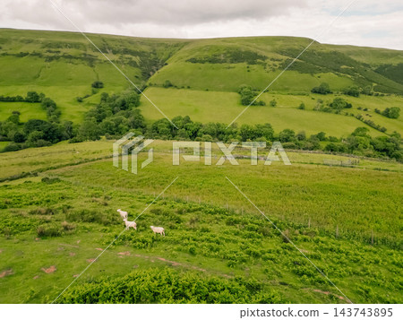 Aerial view of a scenic mountain valley with a winding road through the rugged landscape of Brecon Beacons National Park in Wales, United Kingdom Powys, Wales - 28 August 2026. Aerial view of a scenic mountain valley with a winding road through the rugged landscape of Brecon Beacons National Park in Wales, United Kingdom Powys, Wales - 28 August 2026. 143743895