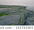 Aerial view of The Burren, a dramatic limestone landscape in County Clare, western Ireland, featuring rugged rocky terrain, green fields and distinctive karst Clare, Ireland - 28 August 2026 143743903