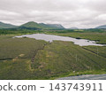 Aerial view of Lough Bofin in the Connemara region of County Galway, Ireland, surrounded by rugged mountains, green countryside and tranquil waters Galway, Ireland - 28 August 2026. 143743911