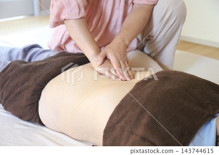 一位女士正在進行腹部按摩。 一位女士正在進行腹部按摩。 143744615