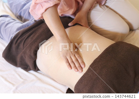 一位女士正在進行腹部按摩。 一位女士正在進行腹部按摩。 143744621