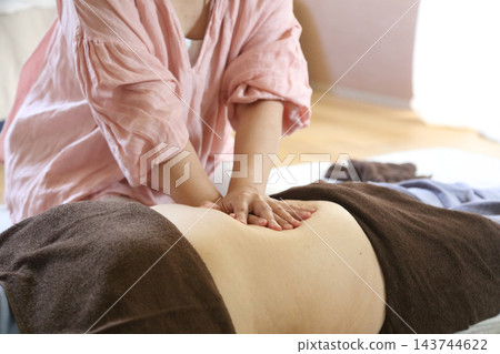 一位女士正在進行腹部按摩。 一位女士正在進行腹部按摩。 143744622