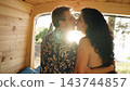 Mature couple kissing inside camper van traveling 143744857