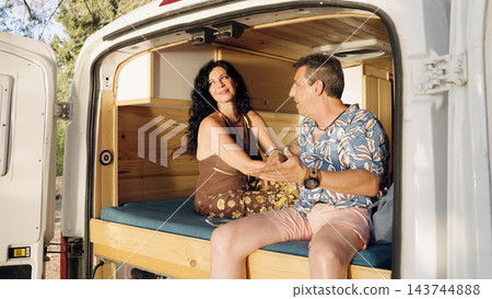Mature couple enjoying camper van road trip lifestyle Mature couple enjoying camper van road trip lifestyle 143744888