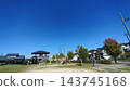 A park and playground in a residential area under a clear blue sky. 143745168