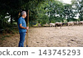 Farmer watching cattle grazing on cheese farm pasture 143745293