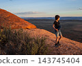 Boy Hiking at Sunset on Devils Garden Trail, Utah 143745404