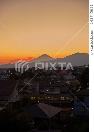 在富士山的夕陽西下,城市燈光開始亮起,映襯著美麗的紅色天空。 在富士山的夕陽西下,城市燈光開始亮起,映襯著美麗的紅色天空。 143745631