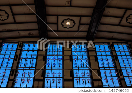 The interior view of JR Otaru Station, with its blue sky visible through the high windows and the glow of lamps, evokes a nostalgic atmosphere. The interior view of JR Otaru Station, with its blue sky visible through the high windows and the glow of lamps, evokes a nostalgic atmosphere. 143746063