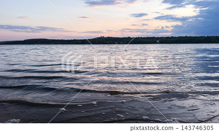 Gentle waves on a lake at dusk beneath a pastel sky Gentle waves on a lake at dusk beneath a pastel sky 143746305