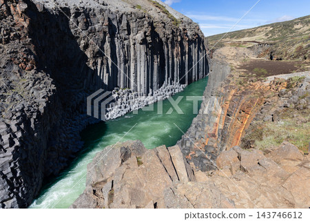 Basalt columns above the turquoise Jokla river in Studlagil canyon, Iceland 143746612