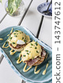 gourmet Eggs Benedict breakfast food on white table at modern restaurant cafe outdoors 143747612