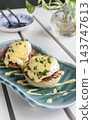 gourmet Eggs Benedict breakfast food on white table at modern restaurant cafe outdoors 143747613