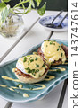 gourmet Eggs Benedict breakfast food on white table at modern restaurant cafe outdoors 143747614