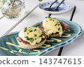 gourmet Eggs Benedict breakfast food on white table at modern restaurant cafe outdoors 143747615