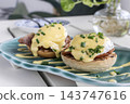 gourmet Eggs Benedict breakfast food on white table at modern restaurant cafe outdoors 143747616