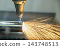Laser beam from a fiber laser cutting machine engraving a steel pipe with sparkling light 143748513
