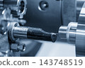 Outside thread making process on steel pipe parts using a CNC lathe machine in a blue tone scene 143748519