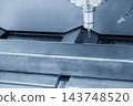 CNC milling machine cutting a metal steel pipe with a flat nose end mill tool in a light blue tone 143748520