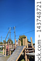 Wooden playground equipment and park scenery under a blue sky 143748721