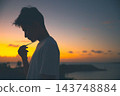 夕陽西下，一位年輕男子側臉祈禱。 143748884
