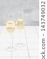 Stylish champagne glasses. On a white tiled counter. 143749032