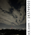 The night city visible through a gap in the clouds 143749503