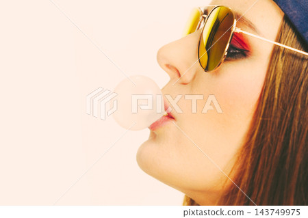 Woman doing bubble with chewing gum Woman doing bubble with chewing gum 143749975