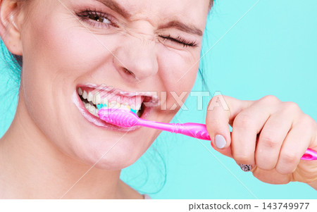 Woman brushing cleaning teeth 143749977