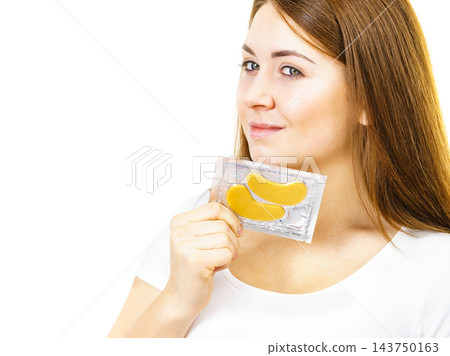 Woman ready to apply gold eye patches Woman ready to apply gold eye patches 143750163