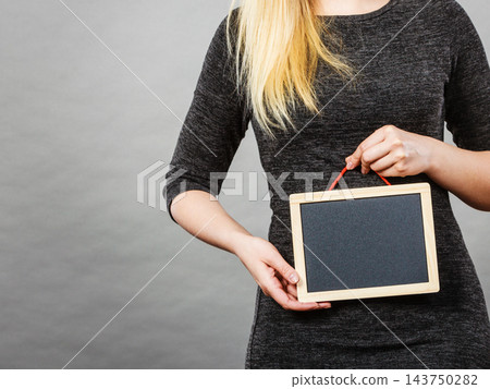 Woman holding blank black board on stomach Woman holding blank black board on stomach 143750282