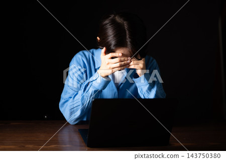 拿著她的在一台個人計算機前面的婦女頭 拿著她的在一台個人計算機前面的婦女頭 143750380