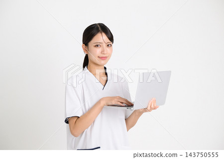 美容院的一名女員工正在操作筆記型電腦。 143750555