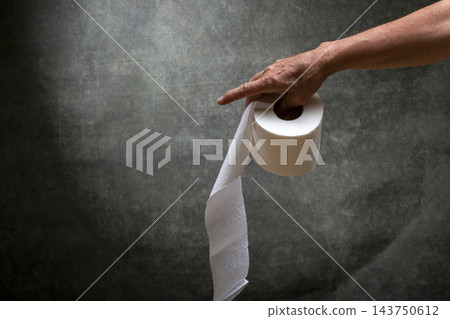 Man's right hand holding a roll of white toilet paper Man's right hand holding a roll of white toilet paper 143750612