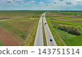 Aerial view of highway crossing green agricultural fields 143751514