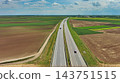 Aerial view of highway crossing green agricultural fields 143751515