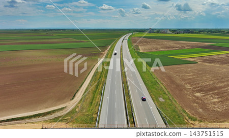 Aerial view of highway crossing green agricultural fields Aerial view of highway crossing green agricultural fields 143751515