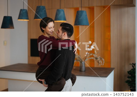 Couple enjoying a loving moment in a modern living space during daytime Couple enjoying a loving moment in a modern living space during daytime 143752143