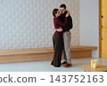 Couple sharing an embrace in a modern indoor space during the day 143752163